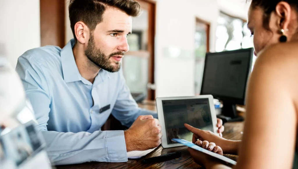 A hotel receptionist using Evenly on an iPad to communicate with a deaf guest